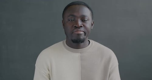 Slow Motion Portrait of Unhappy African American Man Showing Thumbsdown Hand Gesture