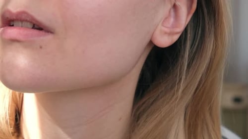 Close Up of Woman Inserting Wireless White Earphone Into Her Ear Listens to Music Footage