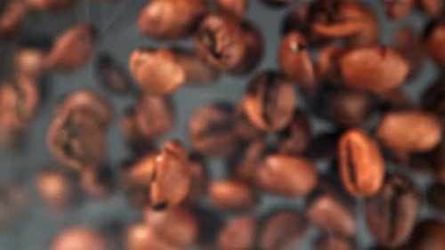 Superzeitlupen-Kaffeebohnen mit Rauch, gefilmt auf einer Hochgeschwindigkeitskamera mit 1000 Bildern pro Sekunde