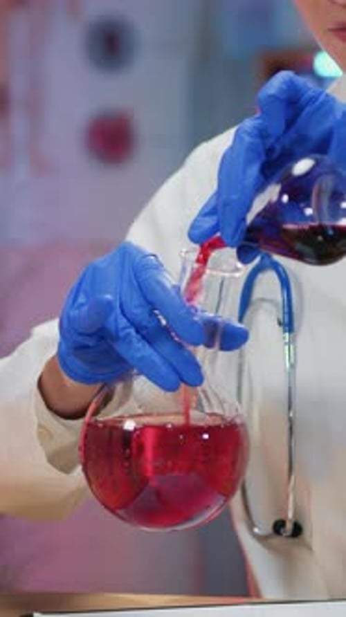 Scientist Mixing Red Liquid in Laboratory Beaker