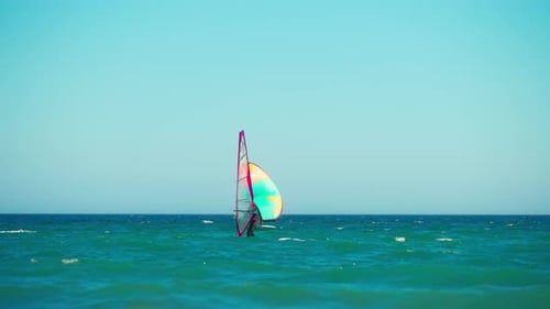 Windsurfers crossing at the sea in slow motion