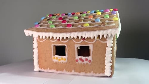 Lebkuchenhaus. Rotierendes weihnachtlich geschmücktes Lebkuchenhaus auf defokussiertem hellem Hintergrund
.