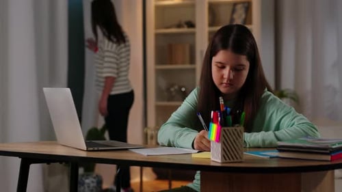Girl Studying at Desk with Laptop in Warm Home