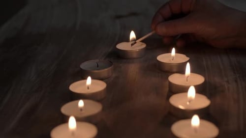 Lighting row of candles with matches
