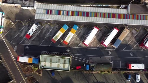 A slow rising shot of a bus depot with lots of stationary busses.