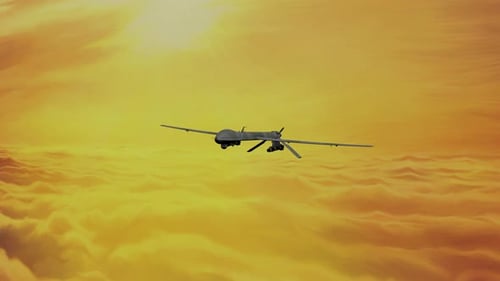 Military Drone Flying Over Golden Clouds at Sunset