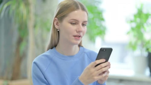 Young Woman Using Smartphone in Home Setting