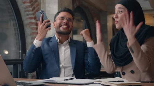 Happy Arabian Business Team Winning with Phone Giving High Five Excited Job Two Colleagues in Office