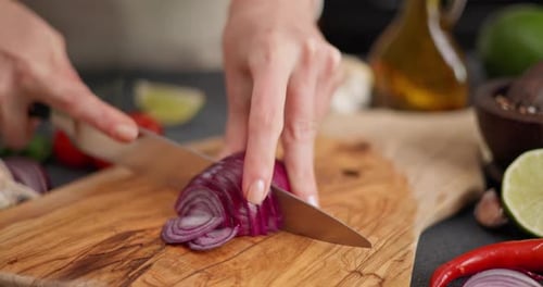 Woman Slicing Red Onion for Fresh Dish