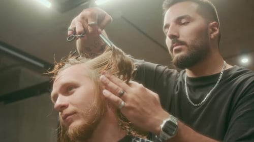 Creative Young Barber Giving Customer Stylish Haircut in Salon
