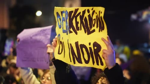 Crowd Holds Signs at Night Time Demonstration