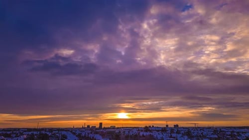 Aerial timelapse of sunset over snow covered suburban area