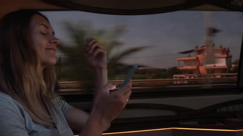 Beautiful Young Female Texting on Smartphone While Riding in a Cab Passing Suburbs in Turkey and