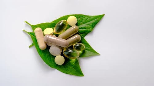 Pills and Capsules on a Leaf Close Up