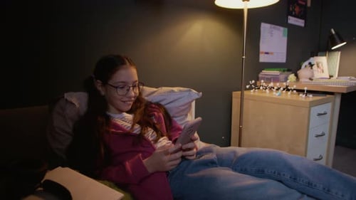 Teen Girl Lying on Couch Using Mobile Phone
