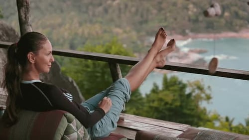 Femme assise sur un banc avec les pieds en l'air