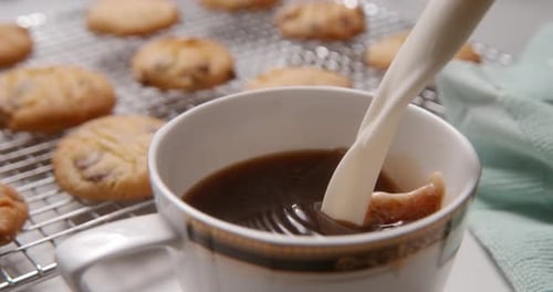 Milk poured into nice coffee cup with cookies 2000 fps Phantom