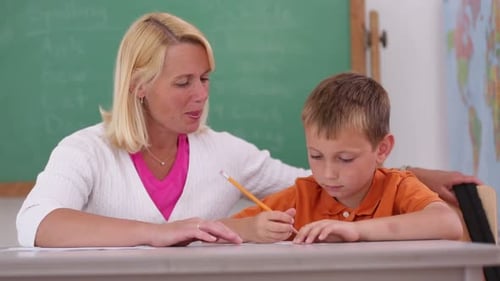 Teacher at School Helps Student in Classroom 30s