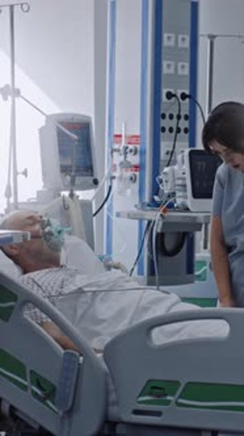 Friendly Nurse Talks to Old Patient Lying in Bed Takes Care