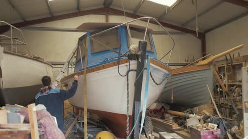 Jovem aprendiz de armador embarca em barco de fibra de vidro para inspecionar canhões