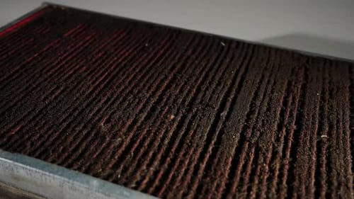 Nahaufnahme eines alten und verschmutzten Autoluftfilters mit Rotation
