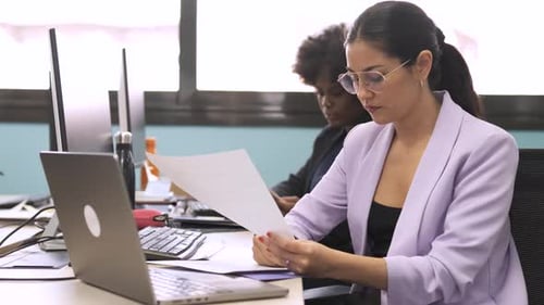 Woman Reviews Documents in Modern Office Workplace