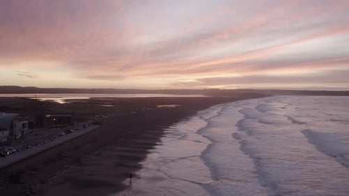 Dawn sunrise aerial rises above beach town sand dunes, Tramore, IRL