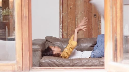 Girl Relaxing at Home on Couch With Smartphone