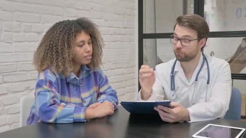 Doctor Consults with Patient at Clinic Examination Table