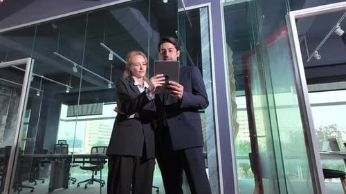 Business meeting in modern office between two professionals discussing documents