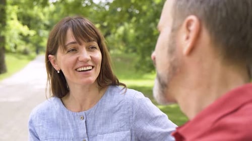 Woman Laughing in Conversation with a Man in Park