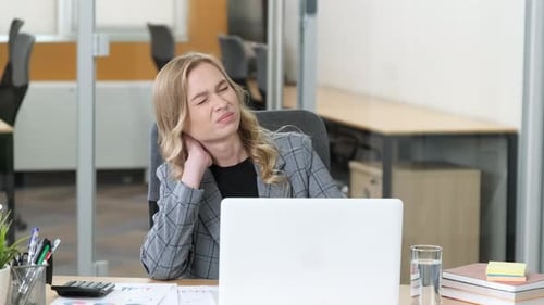 Professional Working on Her Laptop in a Modern Office