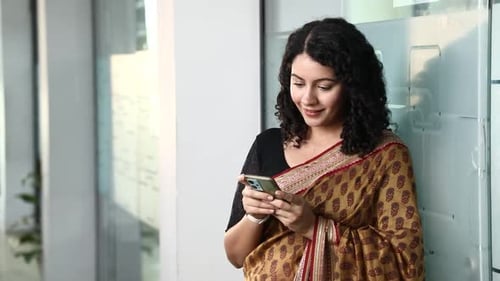 Happy Woman Presents Smartphone in Office Setting