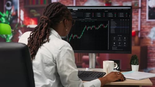 Day Trader Using PC to Sell Stocks Aiming to Capitalize on Market Trends