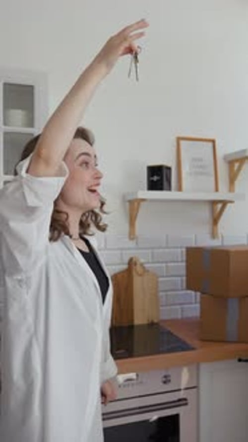 Vertical of Happy Woman and Man Show Key to New Apartment at Camera