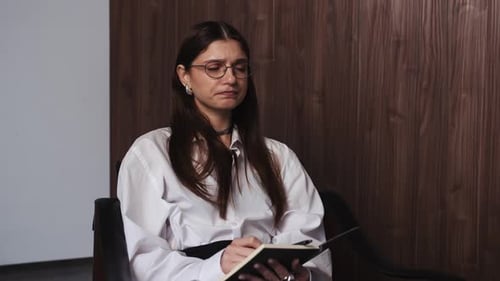 Young Woman Psychologist at Mental Therapy Talking to Client Listening and Taking Notes