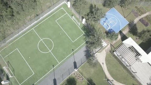Aerial shot overhead a half basketball court and football field in a community
