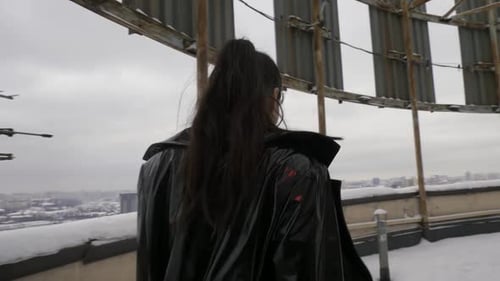 Woman Walking on Snowy Rooftop in Winter