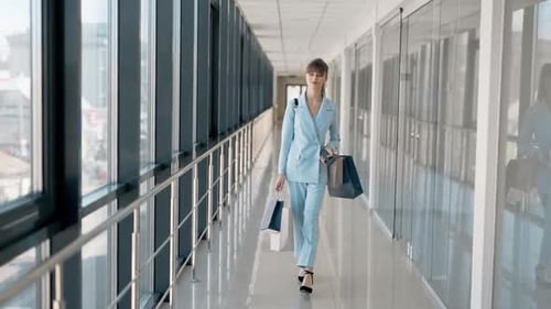 Elegant Woman Walking with Shopping Bags in Office