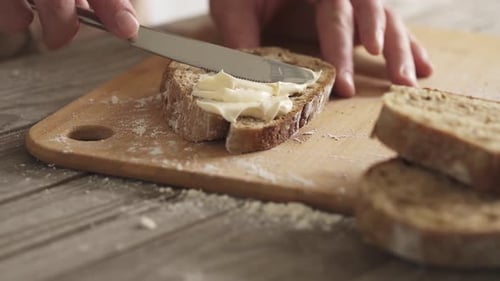 Spreading Cream Cheese on Bread Slice at Home