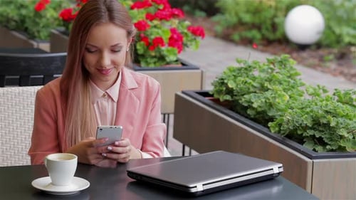 Girl Using Her Mobile Phone in Cafe