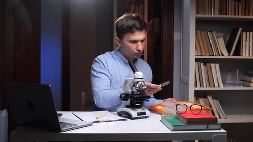Scientist Preparing Microscope Slide in Laboratory at Night