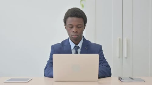 Young Adult Working on Laptop in Office