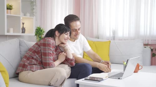 Couple Relaxing on Couch Watching Laptop Together