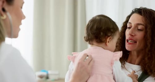 Doctor Examines Infant with Stethoscope Held by Mother