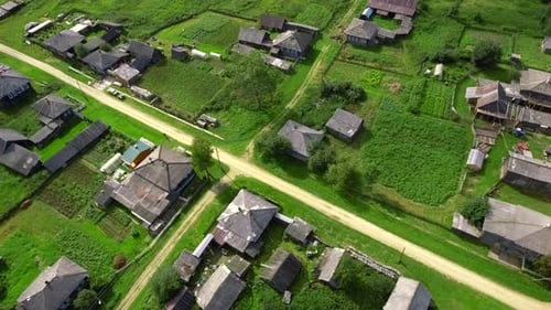 Top view of rustic cottages with green fields