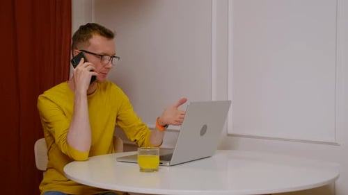 Un homme d'âge moyen consulte son comptable tout en remplissant un formulaire d'impôt