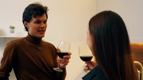 Couple Enjoying Wine Together in Modern Kitchen During a Cozy Evening