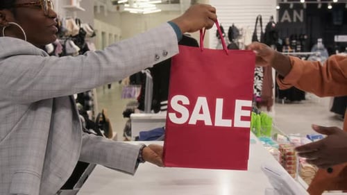 Person Receiving Sale Bag at Clothing Store Checkout