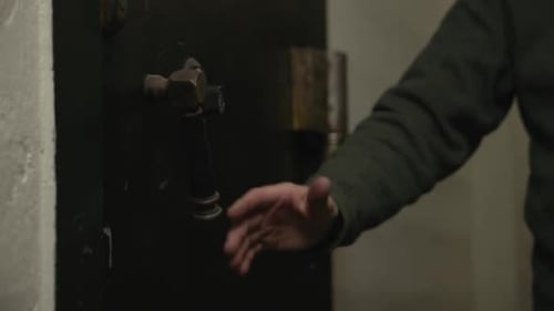 Hand Turns Handle on an Old Door